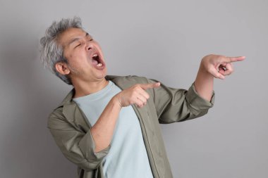 Gri arka planda duran 40 'lı yılların Asyalı, şık, sıradan elbiseli adamı.. 