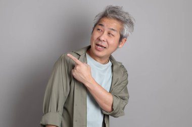 Gri arka planda duran 40 'lı yılların Asyalı, şık, sıradan elbiseli adamı.. 