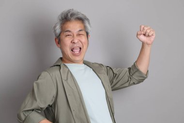 Gri arka planda duran 40 'lı yılların Asyalı, şık, sıradan elbiseli adamı.. 