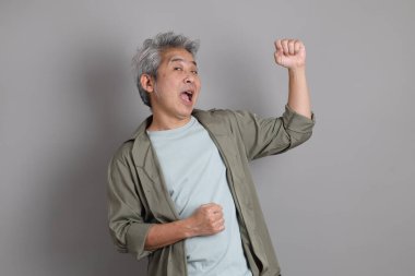 Gri arka planda duran 40 'lı yılların Asyalı, şık, sıradan elbiseli adamı.. 