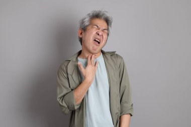 Gri arka planda duran 40 'lı yılların Asyalı, şık, sıradan elbiseli adamı.. 