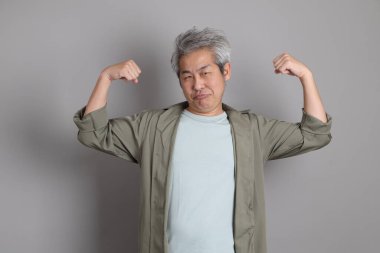 Gri arka planda duran 40 'lı yılların Asyalı, şık, sıradan elbiseli adamı.. 