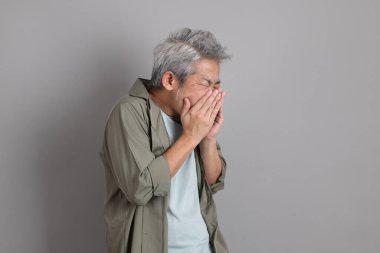 Gri arka planda duran 40 'lı yılların Asyalı, şık, sıradan elbiseli adamı.. 