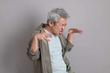 Gri arka planda duran 40 'lı yılların Asyalı, şık, sıradan elbiseli adamı.. 