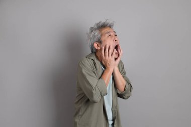 Gri arka planda duran 40 'lı yılların Asyalı, şık, sıradan elbiseli adamı.. 