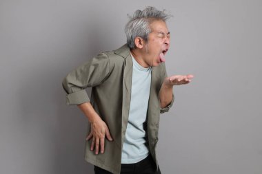 Gri arka planda duran 40 'lı yılların Asyalı, şık, sıradan elbiseli adamı.. 