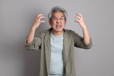 Gri arka planda duran 40 'lı yılların Asyalı, şık, sıradan elbiseli adamı.. 