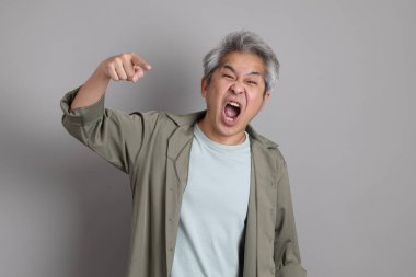 Gri arka planda duran 40 'lı yılların Asyalı, şık, sıradan elbiseli adamı.. 