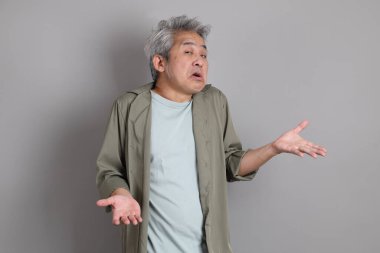 Gri arka planda duran 40 'lı yılların Asyalı, şık, sıradan elbiseli adamı.. 