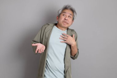 Gri arka planda duran 40 'lı yılların Asyalı, şık, sıradan elbiseli adamı.. 