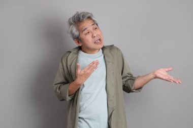 Gri arka planda duran 40 'lı yılların Asyalı, şık, sıradan elbiseli adamı.. 