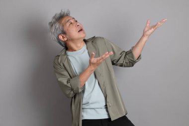 Gri arka planda duran 40 'lı yılların Asyalı, şık, sıradan elbiseli adamı.. 