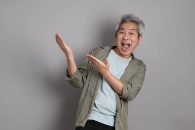 Gri arka planda duran 40 'lı yılların Asyalı, şık, sıradan elbiseli adamı.. 