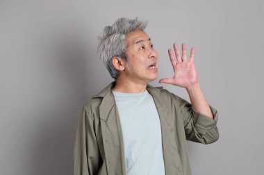 Gri arka planda duran 40 'lı yılların Asyalı, şık, sıradan elbiseli adamı.. 