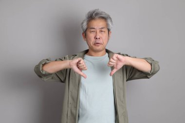 Gri arka planda duran 40 'lı yılların Asyalı, şık, sıradan elbiseli adamı.. 