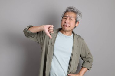 Gri arka planda duran 40 'lı yılların Asyalı, şık, sıradan elbiseli adamı.. 