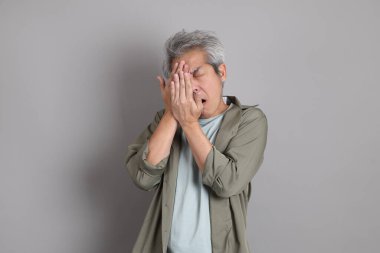 Gri arka planda duran 40 'lı yılların Asyalı, şık, sıradan elbiseli adamı.. 