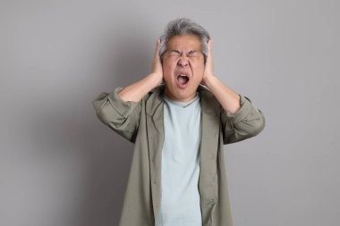 Gri arka planda duran 40 'lı yılların Asyalı, şık, sıradan elbiseli adamı.. 