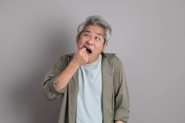 Gri arka planda duran 40 'lı yılların Asyalı, şık, sıradan elbiseli adamı.. 