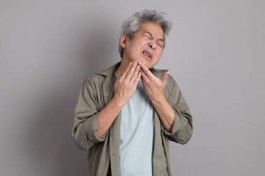 Gri arka planda duran 40 'lı yılların Asyalı, şık, sıradan elbiseli adamı.. 