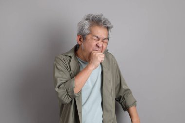 Gri arka planda duran 40 'lı yılların Asyalı, şık, sıradan elbiseli adamı.. 