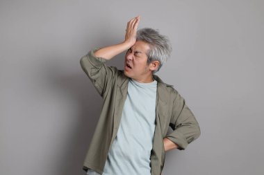 Gri arka planda duran 40 'lı yılların Asyalı, şık, sıradan elbiseli adamı.. 