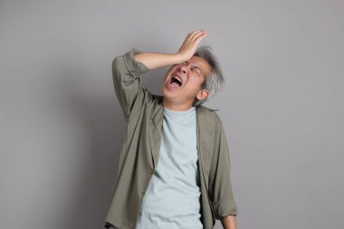 Gri arka planda duran 40 'lı yılların Asyalı, şık, sıradan elbiseli adamı.. 