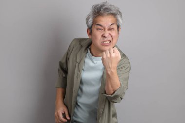 Gri arka planda duran 40 'lı yılların Asyalı, şık, sıradan elbiseli adamı.. 