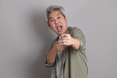 Gri arka planda duran 40 'lı yılların Asyalı, şık, sıradan elbiseli adamı.. 