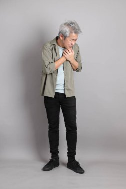 Gri arka planda duran 40 'lı yılların Asyalı, şık, sıradan elbiseli adamı.. 