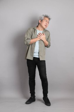 Gri arka planda duran 40 'lı yılların Asyalı, şık, sıradan elbiseli adamı.. 