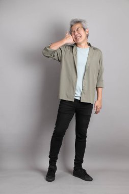 Gri arka planda duran 40 'lı yılların Asyalı, şık, sıradan elbiseli adamı.. 