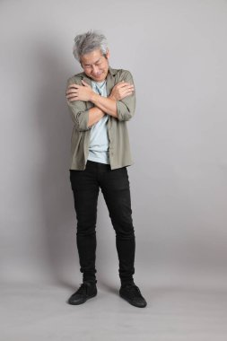 Gri arka planda duran 40 'lı yılların Asyalı, şık, sıradan elbiseli adamı.. 