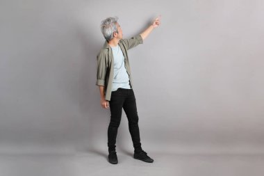 Gri arka planda duran 40 'lı yılların Asyalı, şık, sıradan elbiseli adamı.. 