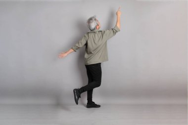 Gri arka planda duran 40 'lı yılların Asyalı, şık, sıradan elbiseli adamı.. 