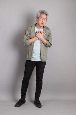 Gri arka planda duran 40 'lı yılların Asyalı, şık, sıradan elbiseli adamı.. 