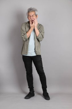 Gri arka planda duran 40 'lı yılların Asyalı, şık, sıradan elbiseli adamı.. 