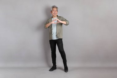 Gri arka planda duran 40 'lı yılların Asyalı, şık, sıradan elbiseli adamı.. 