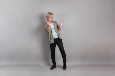 Gri arka planda duran 40 'lı yılların Asyalı, şık, sıradan elbiseli adamı.. 