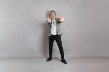 Gri arka planda duran 40 'lı yılların Asyalı, şık, sıradan elbiseli adamı.. 