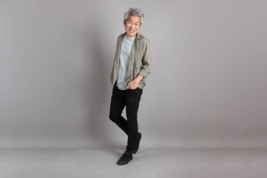 Gri arka planda duran 40 'lı yılların Asyalı, şık, sıradan elbiseli adamı.. 