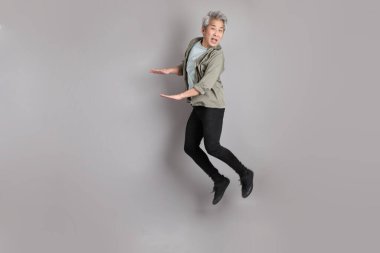 Gri arka planda duran 40 'lı yılların Asyalı, şık, sıradan elbiseli adamı.. 