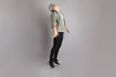 Gri arka planda duran 40 'lı yılların Asyalı, şık, sıradan elbiseli adamı.. 