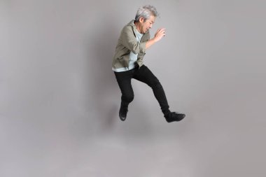 Gri arka planda duran 40 'lı yılların Asyalı, şık, sıradan elbiseli adamı.. 