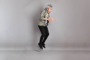 Gri arka planda duran 40 'lı yılların Asyalı, şık, sıradan elbiseli adamı.. 