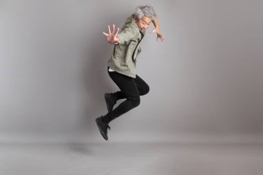 Gri arka planda duran 40 'lı yılların Asyalı, şık, sıradan elbiseli adamı.. 