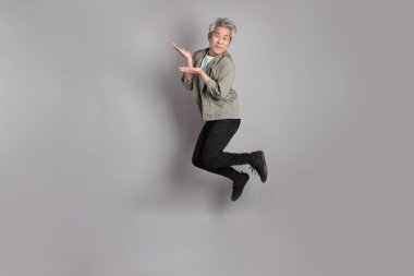 Gri arka planda duran 40 'lı yılların Asyalı, şık, sıradan elbiseli adamı.. 