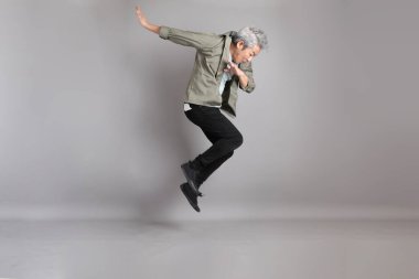 Gri arka planda duran 40 'lı yılların Asyalı, şık, sıradan elbiseli adamı.. 