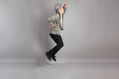 Gri arka planda duran 40 'lı yılların Asyalı, şık, sıradan elbiseli adamı.. 