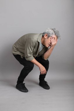 Gri arka planda duran 40 'lı yılların Asyalı, şık, sıradan elbiseli adamı.. 